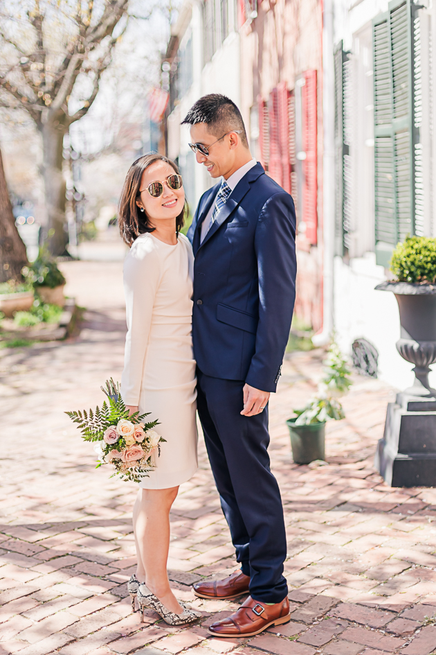 elopement couple standing under cherry blossoms in old town alexandria