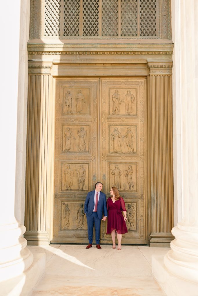 couple standing in front of bronze door of supreme court
