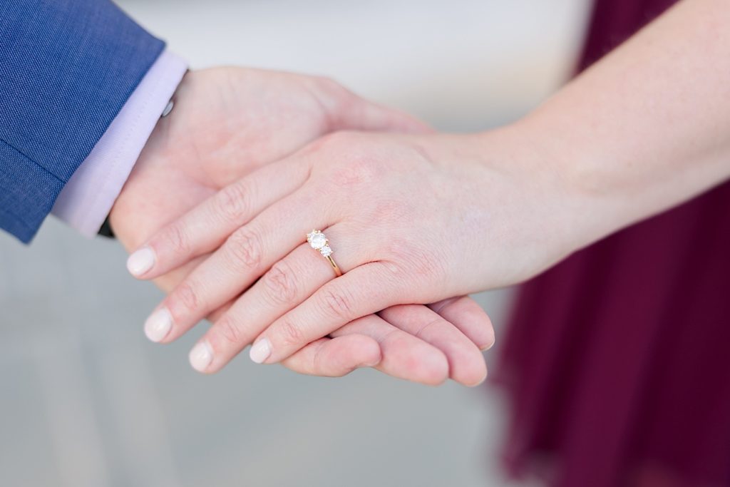 man holding fiances hand with engagement ring
