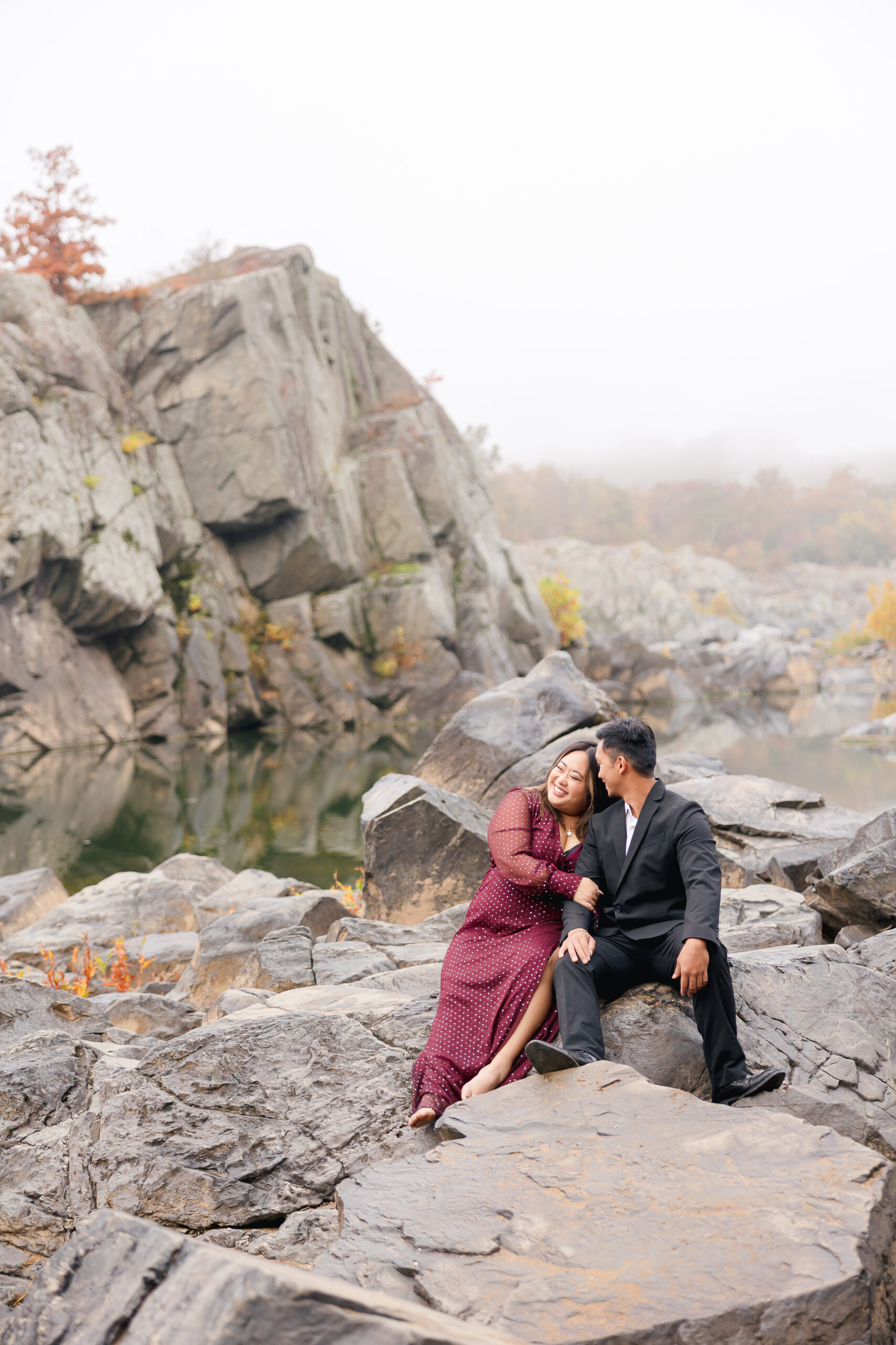 great falls engagement session couple sitting on rocks